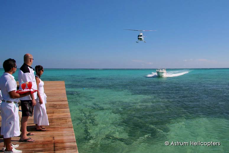 An Astrum Helicopter is greeted as it comes in over the dock at Azul Belize